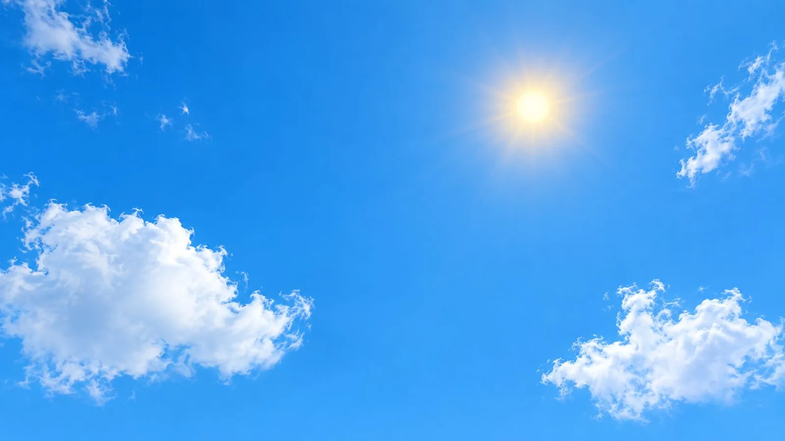 A vibrant blue sky with a glowing sun and scattered white cumulus clouds during the day.